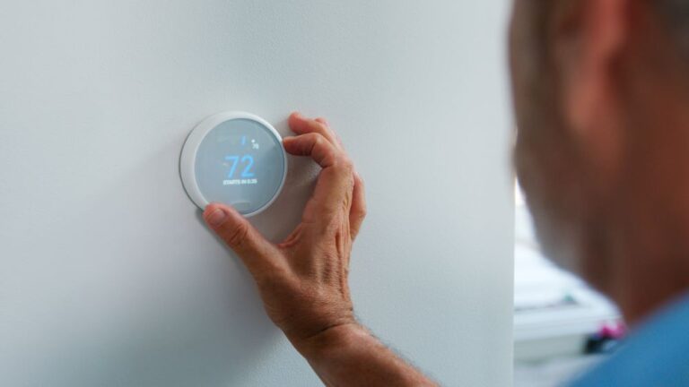 Man changing thermostat settings