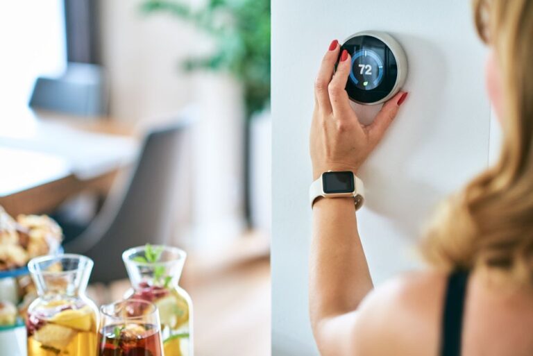 woman setting thermostat in kitchen