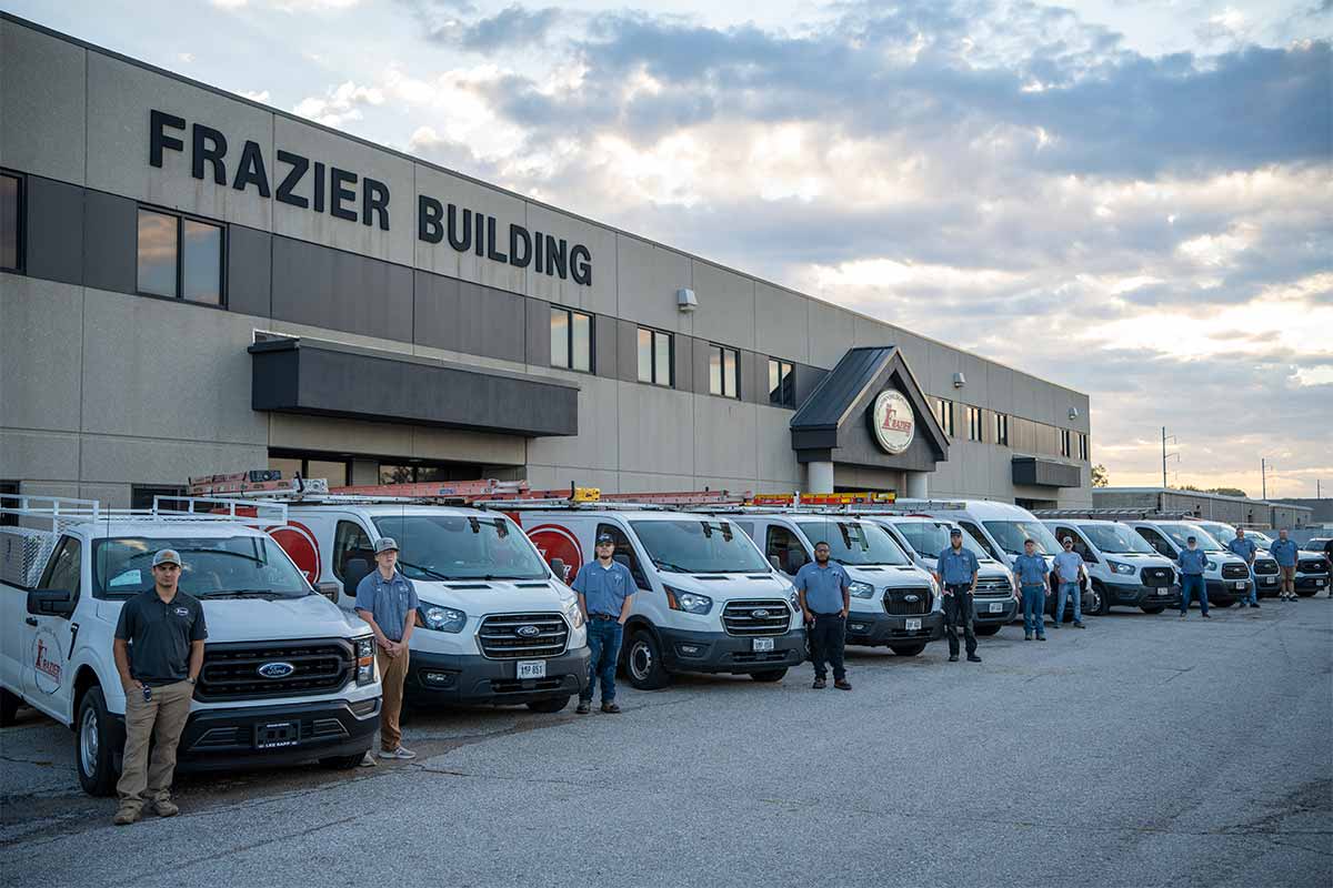 The Frazier Company team and vans in front of building