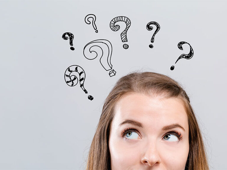 Hand draw question marks with young woman looking upwards